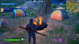 Fortnite campfire locations: A player standing next to a lit campfire surrounded by tents in Fortnite.