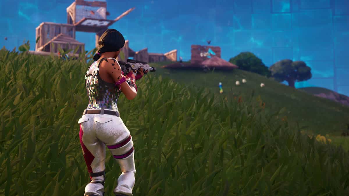 A woman is standing in a field with a gun, while searching for the best graphic settings for Fortnite on her PC.