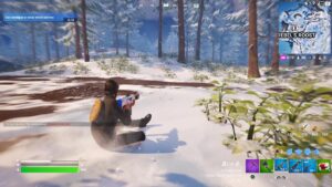 A man is sitting in the snow in a video game, sliding effortlessly around the island.
