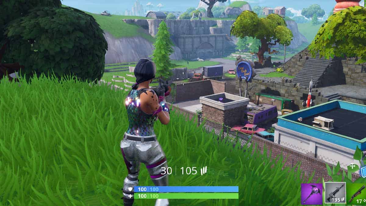 A character in a video game looking at the fortnite og map with ruins and trees, holding a gun, with an ammo and health display visible.