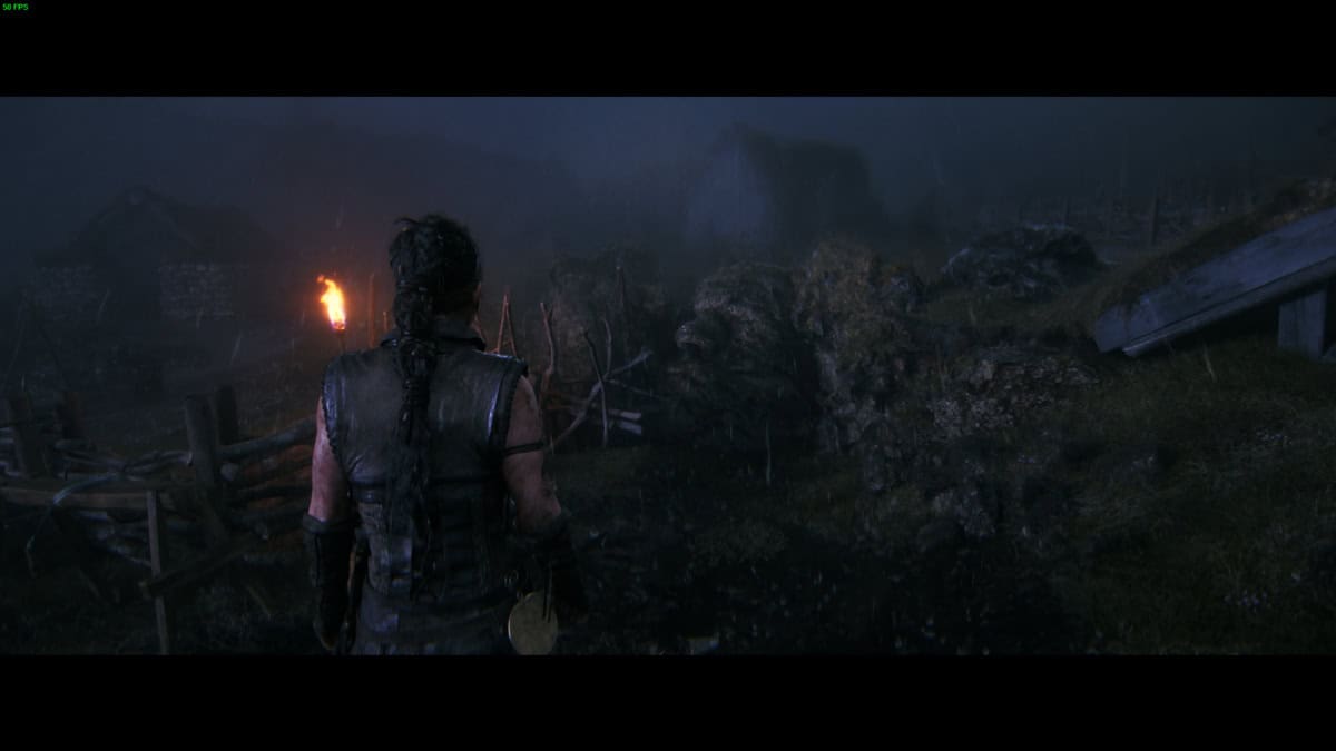 Hellblade 2 Hidden Faces: Senua stands in front of a dark and foggy landscape.