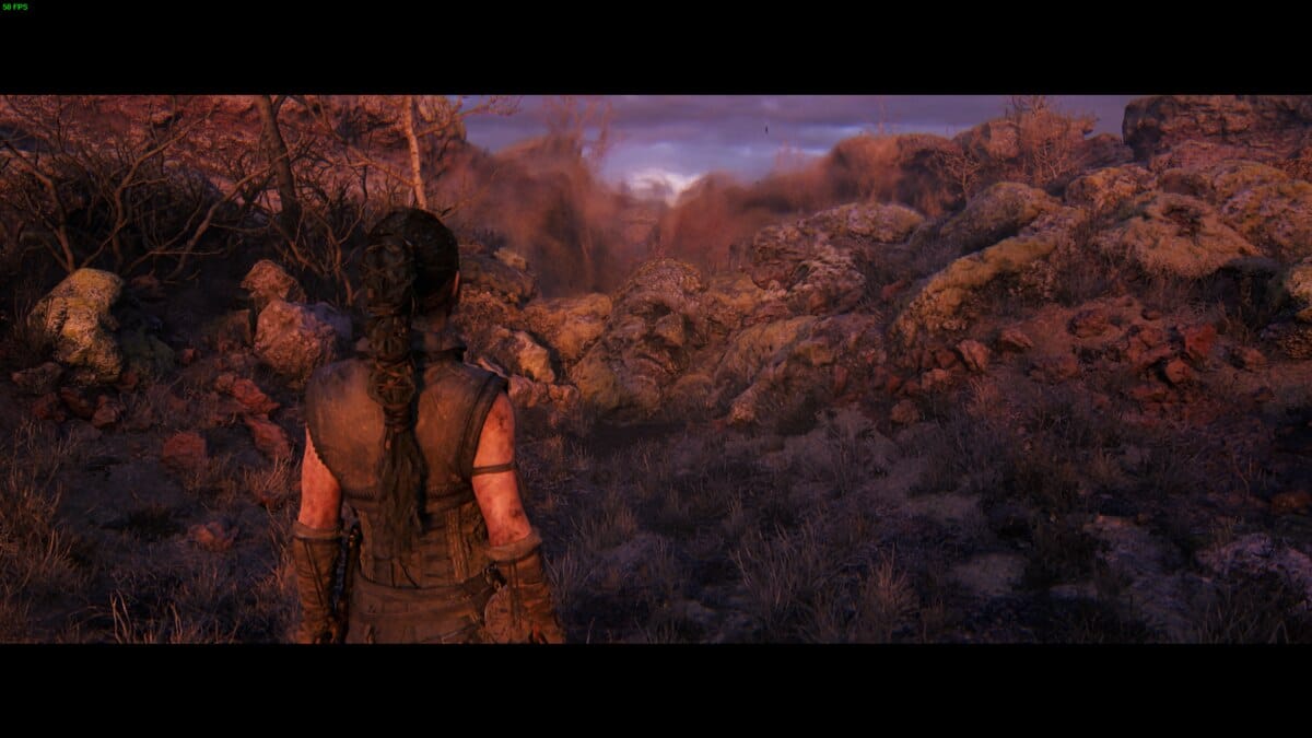 Hellblade 2 Hidden Faces locations: Senua stands in a rocky, barren landscape.