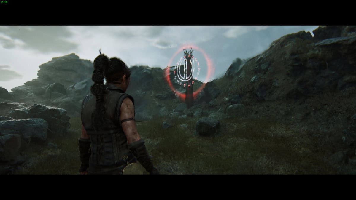 Hellblade 2 Lorestangir locations: Senua stands in a rocky landscape, facing a runic totem.