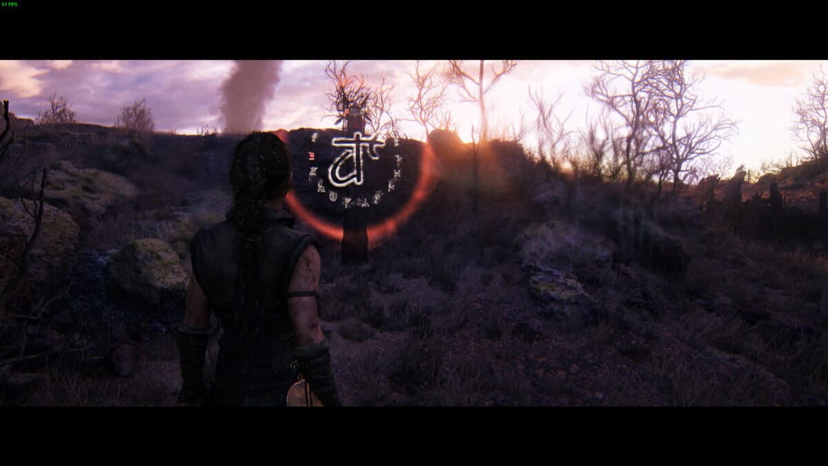 Hellblade 2 Lorestangir locations: Senua stands in a desolate landscape facing a glowing rune symbol with red and white accents at sunset.