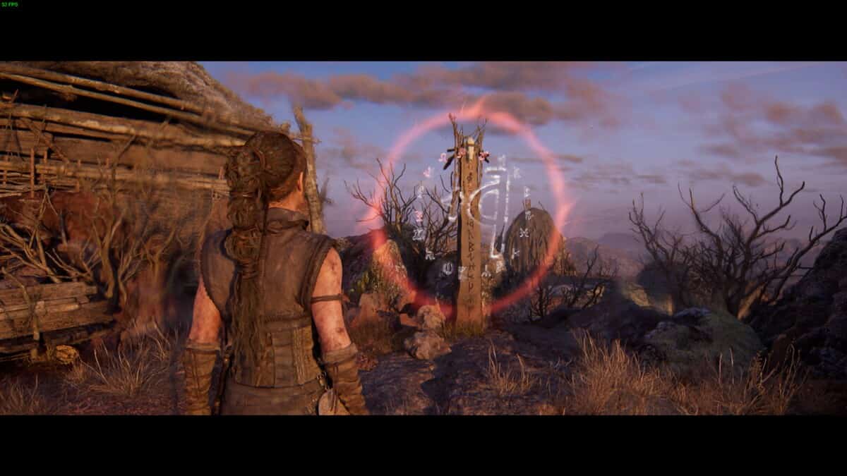Hellblade 2 Lorestangir locations: Senua stands in front of a glowing wooden post covered in symbols, set in a desolate landscape.