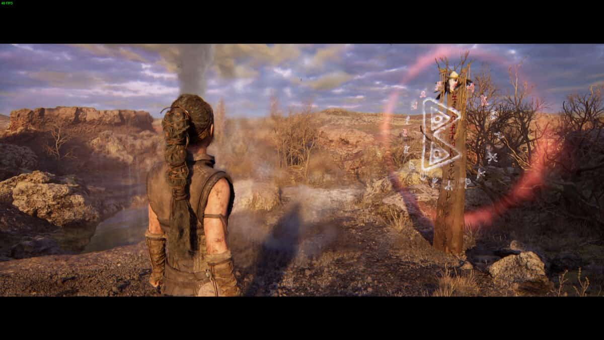 Hellblade 2 Lorestangir locations: Senua looks at glowing runes on a wooden post.