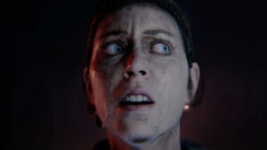 Hellblade 2 review: close-up of Senua with wide, fearful eyes and a slightly open mouth.