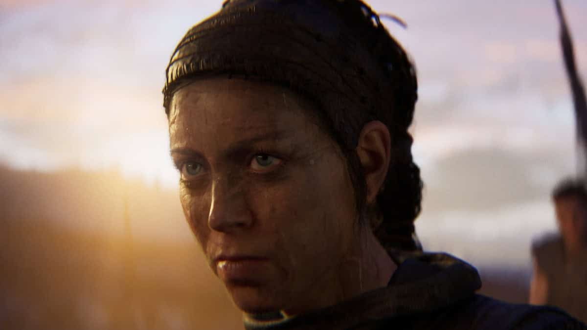 Hellblade 2 trophies and achievements: character Senua bearing a serious expression with the setting sun behind her.