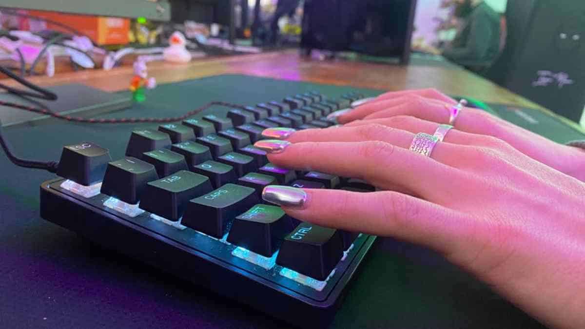 A person's hands are typing on a keyboard while conducting a Steelseries Apex 9 TKL review.