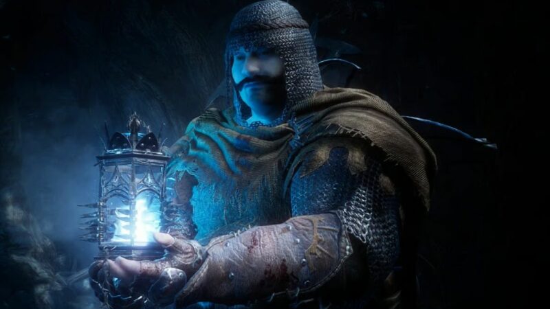 A man wielding a torch in the darkness: Lords of the Fallen.