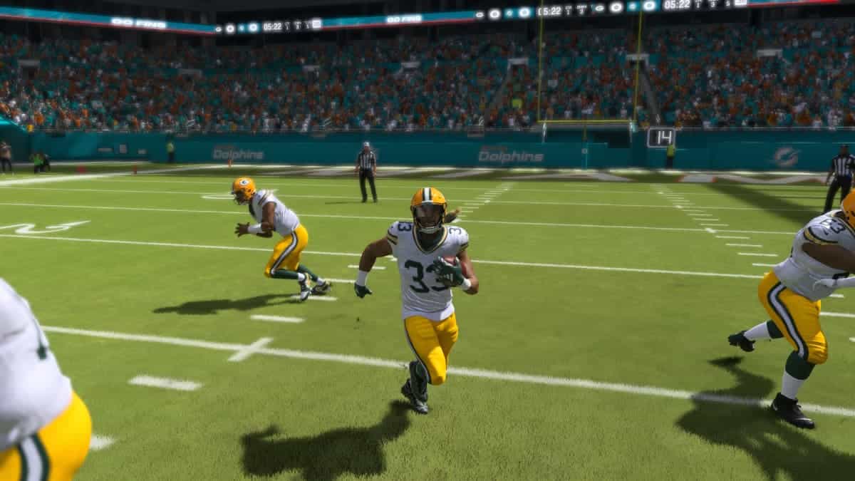 The green bay packers are running on the field as Madden 24 announcers provide commentary.