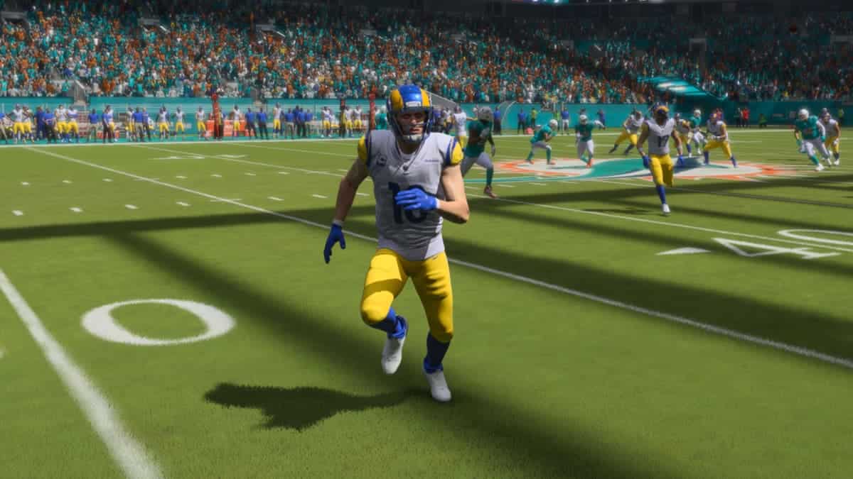 An nfl game with a player running on the field while showcasing their Madden 24 WR ratings.
