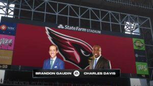 Madden 25 commentators: Headshots of two commentators imposed over footage of a football stadium.