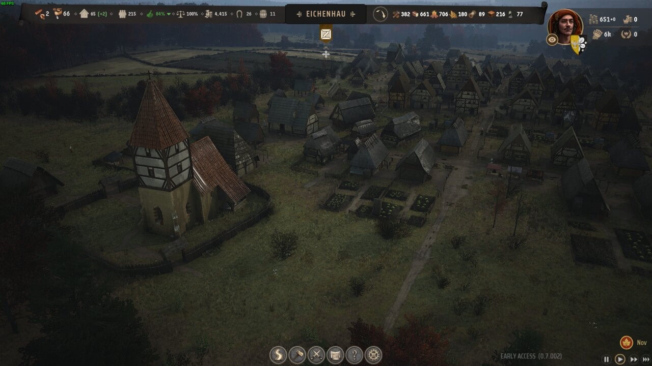 Manor Lords best layout: a medieval village featuring a large church and numerous small houses surrounded by autumn trees.
