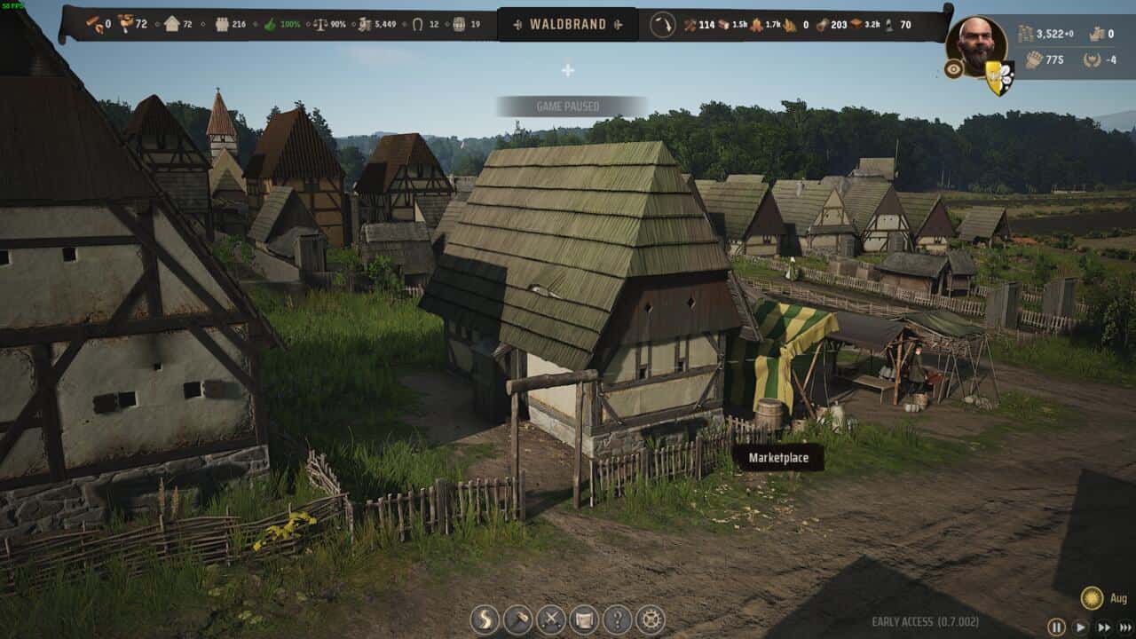 Manor Lords buildings: Screenshot of a medieval village from Manor Lords, showing thatched-roof houses, a marketplace, and game interface elements like resources and a character icon.