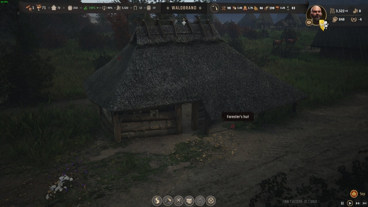 Manor Lords buildings: Screenshot from a video game depicting Manor Lords buildings, including a rustic hut in a medieval village with a thatched roof, surrounded by lush greenery and user interface icons at the top and bottom of the