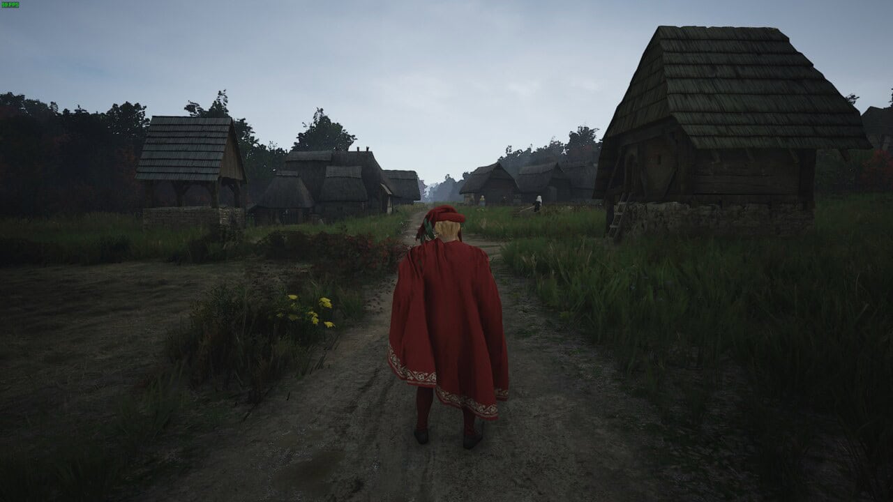 Manor Lords builds: a character dressed in a red cloak and hood walks down a dirt path in a medieval village surrounded by Manor Lords buildings and greenery.