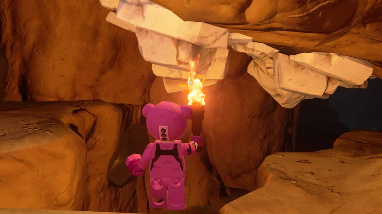 A lego bear standing in a cave torch.