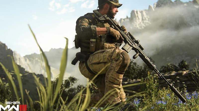 A soldier is kneeling in the grass at one of the fan favourite MW3 maps with a rifle.