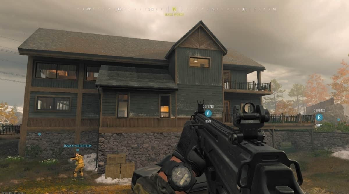 A screenshot showcasing the Best Striker 9 loadout in MW3, with the gun equipped with various attachments and perks, set against the backdrop of a house in Warzone.