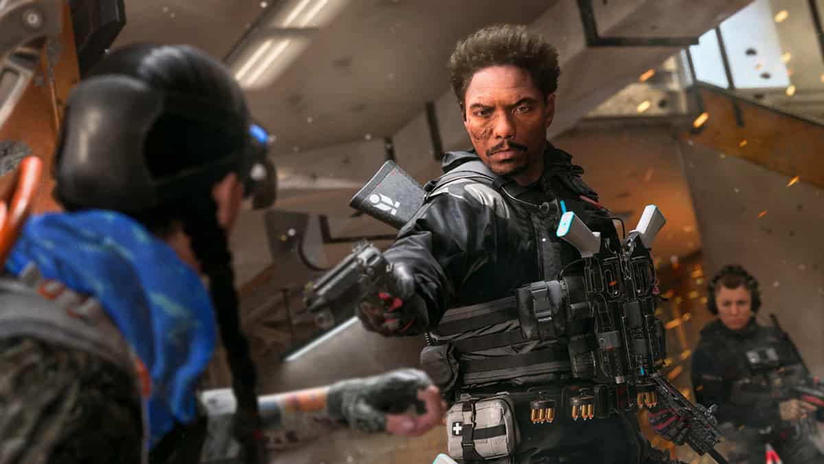 A man wearing tactical gear points his gun at a person.
