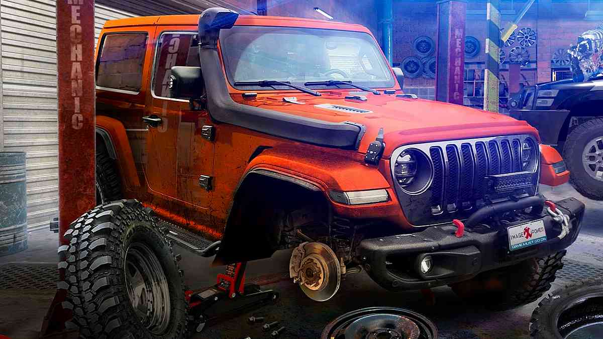 An orange vehicle being worked on in a garage.