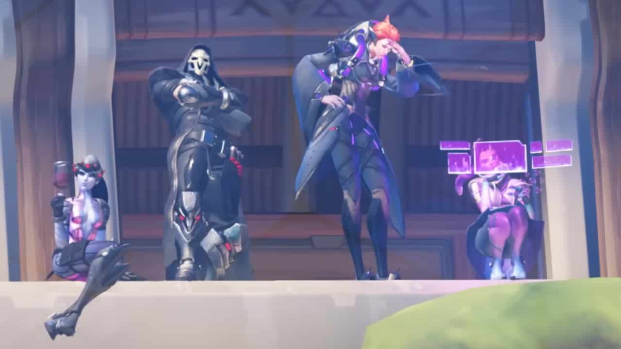 Overwatch 2 Season 8 preload - How do you pre-download the latest season: A group of heroes stand and sit on a ledge, watching an ongoing fight.