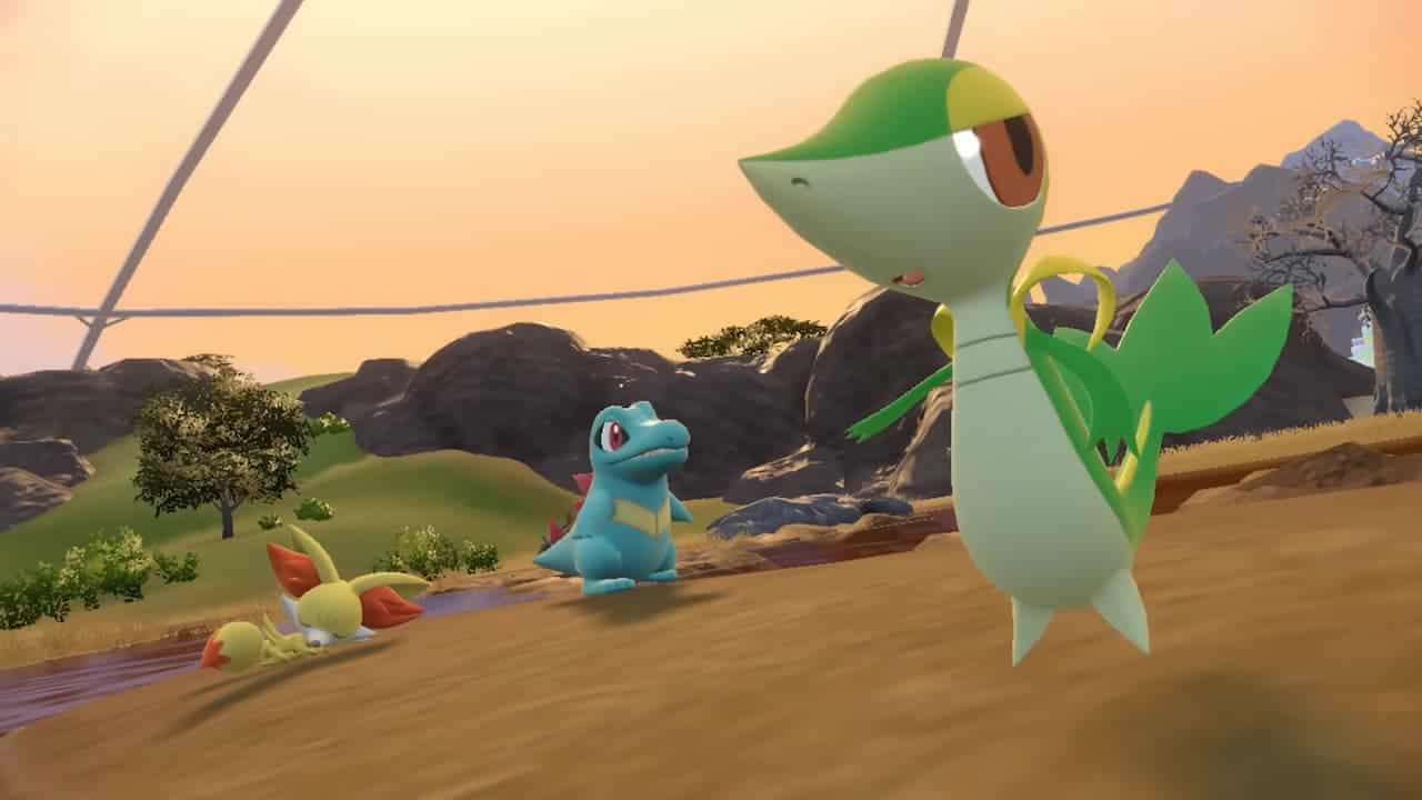A group of Pokemon from the Indigo Disk DLC are standing in a field.