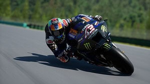 MotoGP 24 release date - A racer in a blue and black suit leans sharply into a turn