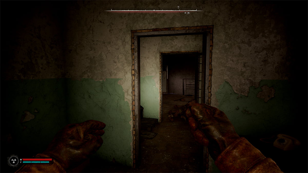 Image of the player using a flashlight to illuminate a set of doorways inside the building in Stalker 2.