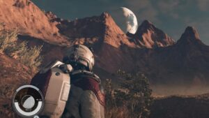 Starfield AMD rewards: An explorer looks up towards a planet hanging in the sky above a mountain range.