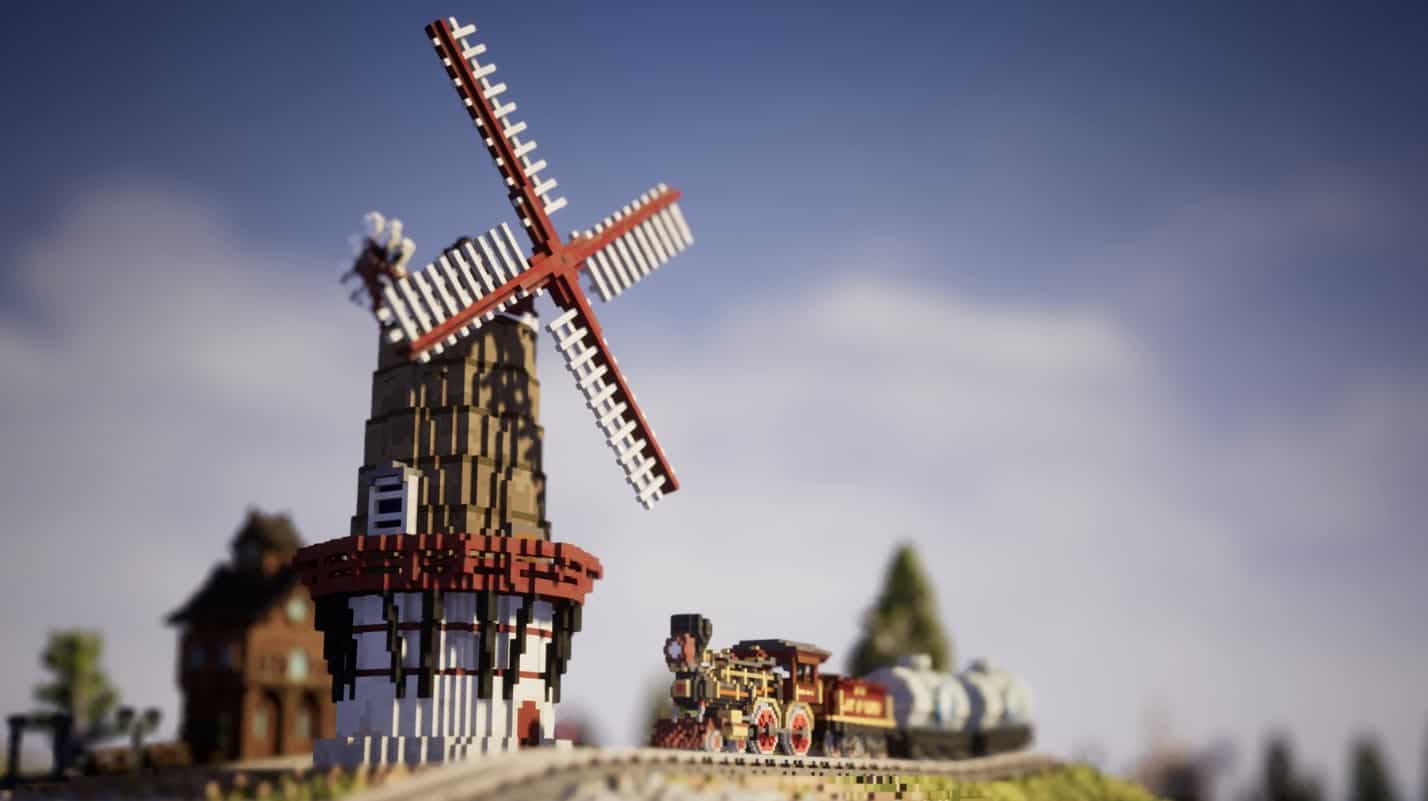 A Lego train with a windmill in the background at a station.