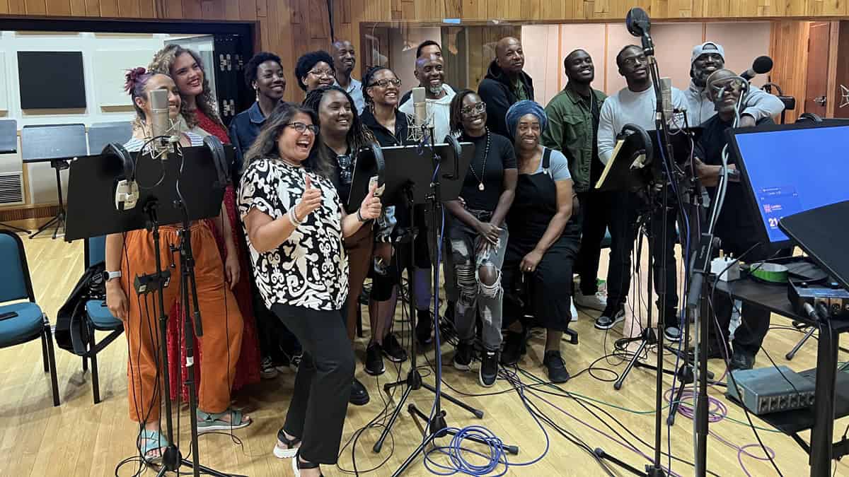 A choir stands next to a set of microphones.