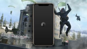 A smartphone displaying a loading symbol superimposed on an illustrated backdrop of characters parachuting into a warzone with military aircraft flying overhead is crashing.