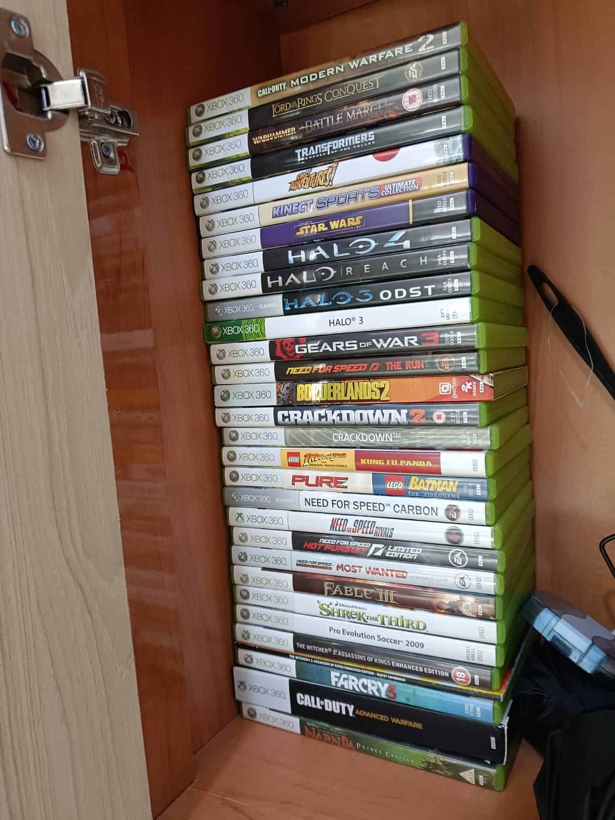 A nostalgic collection of Xbox games in a cabinet, commemorating the lasting impact of the Xbox 360 on my childhood. Image captured by VideoGamer.