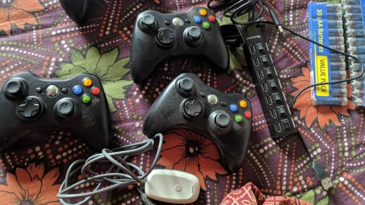 A nostalgic collection of Xbox controllers, wires, and batteries. Image captured by VideoGamer.