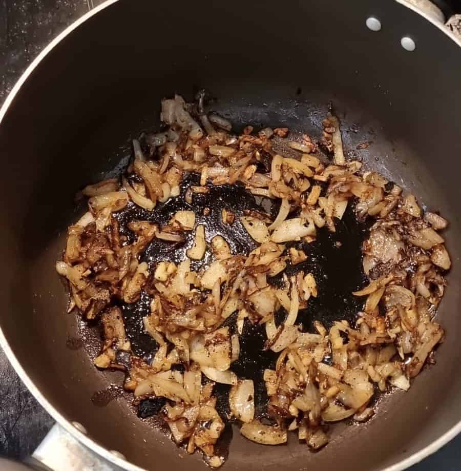 Garlic and onions caramelising in a pan.